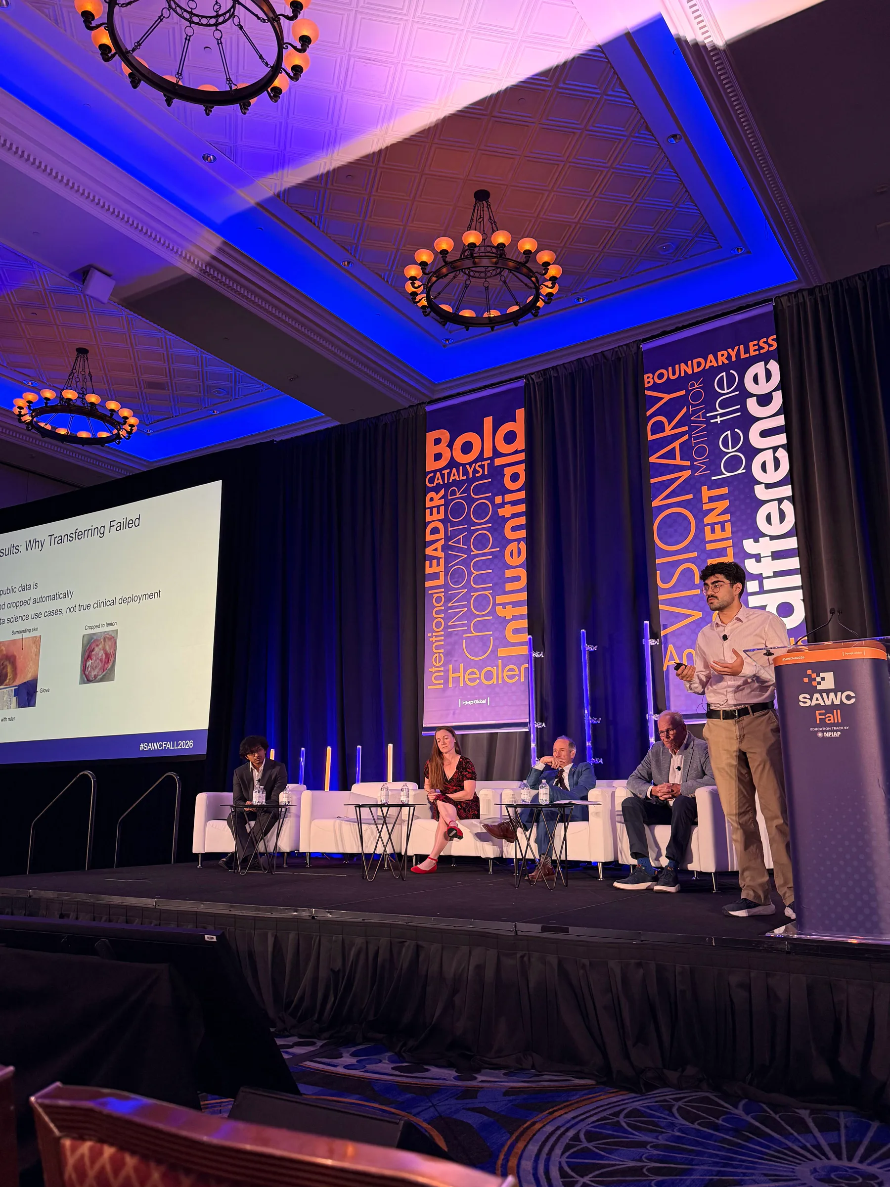 Roshan Parikh presenting the pressure-injury AI generalization study onstage at SAWC Fall 2026